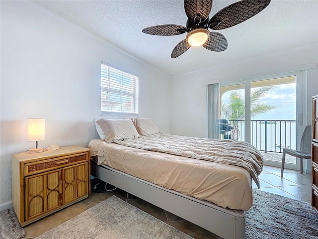 bedroom with ornamental molding, access to outside, a textured ceiling, a ceiling fan, and light tile patterned floors