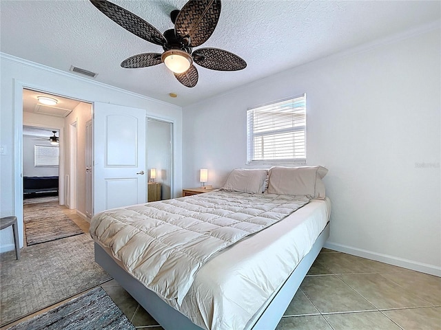bedroom with ceiling fan, a textured ceiling, visible vents, baseboards, and ornamental molding