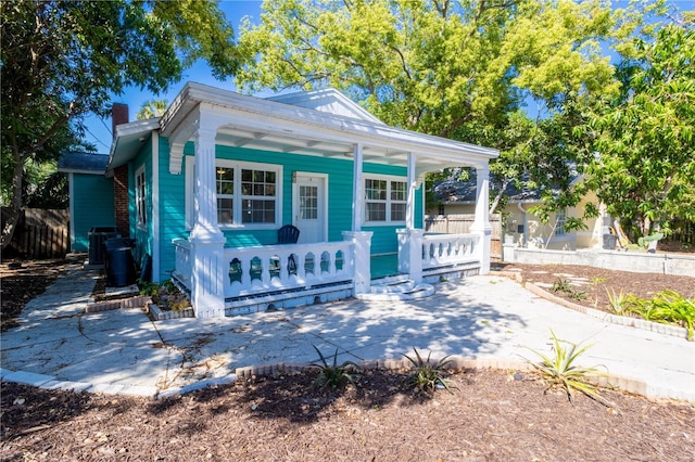 56 W Park St, Tarpon Springs, FL 34689 - view of front of house featuring a porch, a chimney, and fence