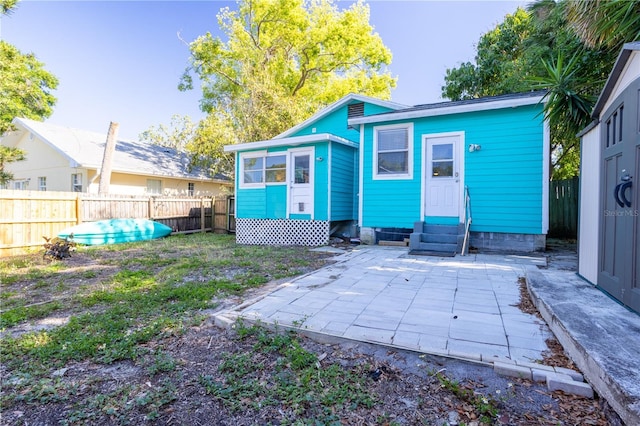 56 W Park St, Tarpon Springs, FL 34689 - back of house featuring entry steps, a patio, and a fenced backyard