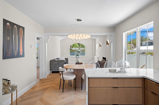 kitchen with a wealth of natural light, open floor plan, pendant lighting, and baseboards