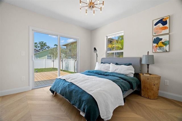 bedroom featuring a notable chandelier, access to outside, and baseboards