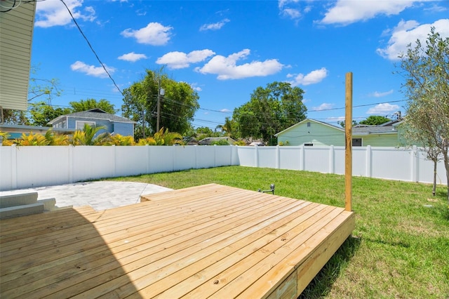 wooden terrace featuring a yard, a fenced backyard, and a patio area