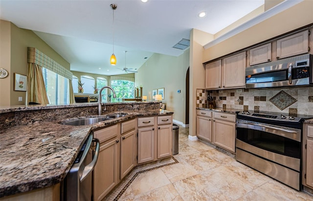 2042 Diamond Ct, Oldsmar, FL 34677 - kitchen featuring stainless steel appliances, dark stone countertops, a sink, pendant lighting, and tasteful backsplash