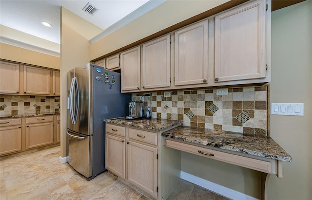 2042 Diamond Ct, Oldsmar, FL 34677 - kitchen featuring light brown cabinets, dark stone countertops, decorative backsplash, visible vents, and freestanding refrigerator