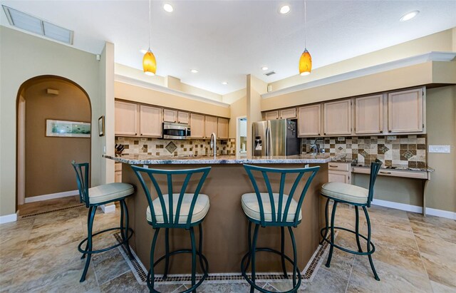 2042 Diamond Ct, Oldsmar, FL 34677 - kitchen with stainless steel appliances, a breakfast bar, pendant lighting, and tasteful backsplash