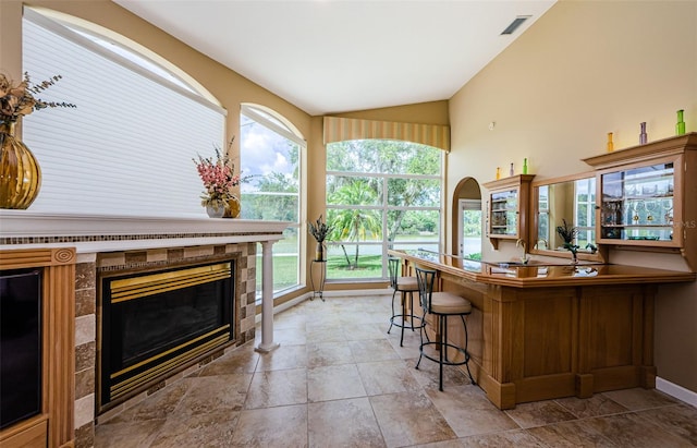 2042 Diamond Ct, Oldsmar, FL 34677 - bar with bar area, vaulted ceiling, baseboards, visible vents, and a tile fireplace