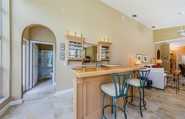 2042 Diamond Ct, Oldsmar, FL 34677 - kitchen with ceiling fan, a towering ceiling, baseboards, and a breakfast bar area
