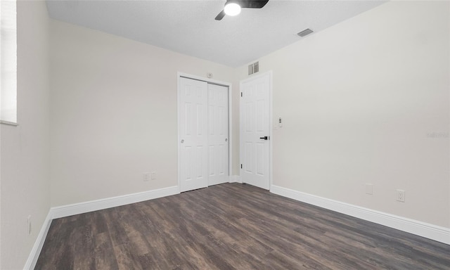 empty room featuring visible vents, baseboards, ceiling fan, and dark wood-style floors