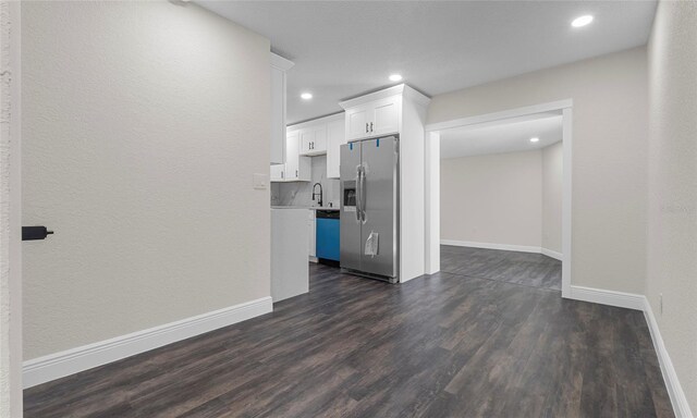 unfurnished living room featuring recessed lighting, baseboards, a sink, and dark wood-type flooring