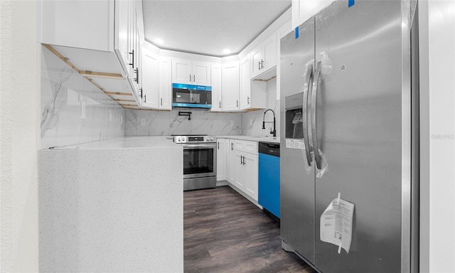 kitchen featuring dark wood-type flooring, recessed lighting, white cabinetry, backsplash, and stainless steel appliances