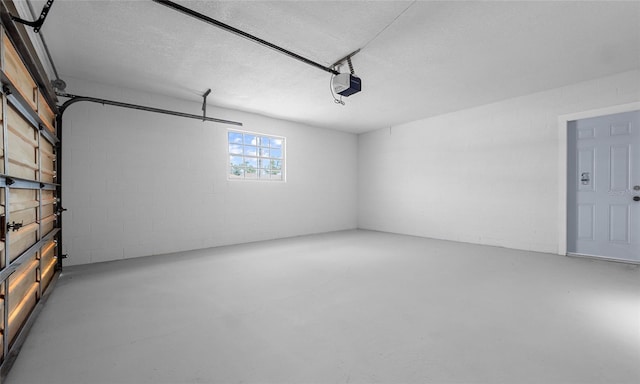 garage with concrete block wall and a garage door opener
