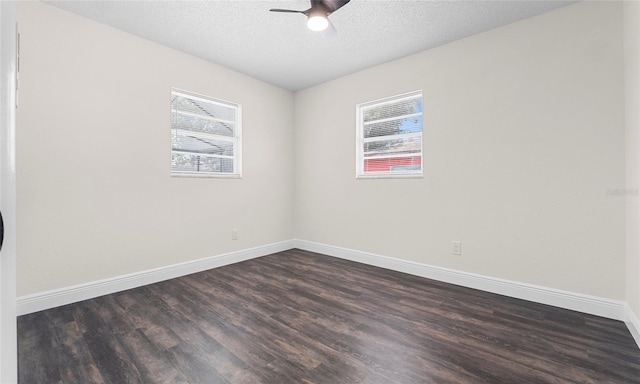 empty room featuring baseboards, ceiling fan, dark wood-style floors, and a textured ceiling