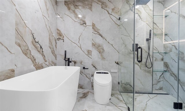 bathroom featuring marble finish floor, a marble finish shower, a soaking tub, and tile walls