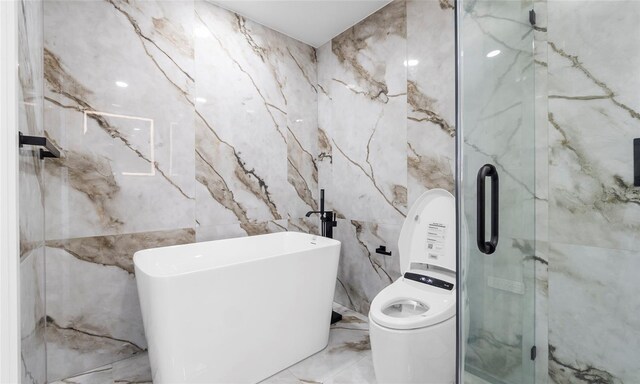 full bathroom with marble finish floor, a freestanding tub, tile walls, washer / clothes dryer, and a marble finish shower