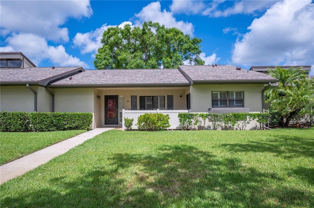 ranch-style house with a front yard and stucco siding