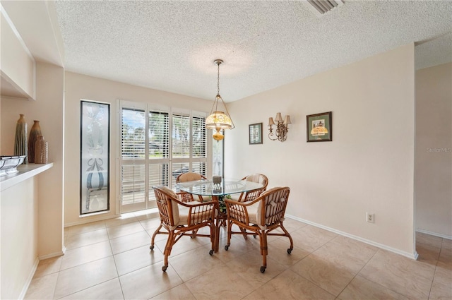 dining space with baseboards, visible vents, and a textured ceiling