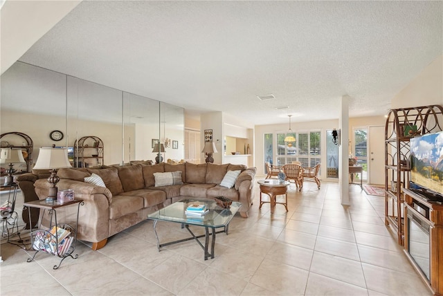 living area with visible vents, a textured ceiling, and light tile patterned flooring