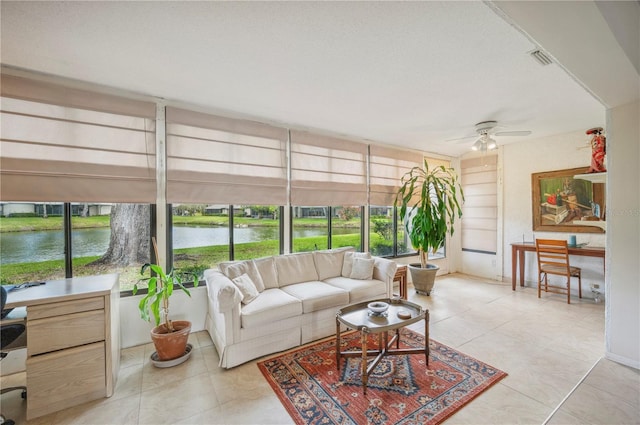 sunroom with outdoor lounge area, a ceiling fan, tile patterned floors, and a water view