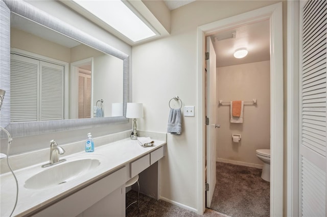 bathroom featuring a closet, toilet, baseboards, and vanity