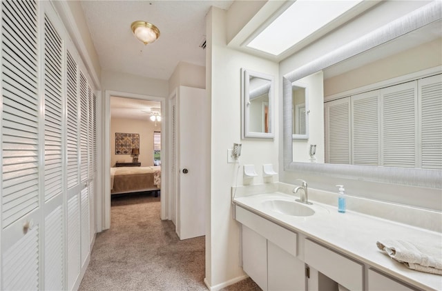 bathroom featuring a ceiling fan, vanity, ensuite bathroom, and a closet