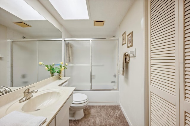 bathroom featuring combined bath / shower with glass door, vanity, a closet, and toilet