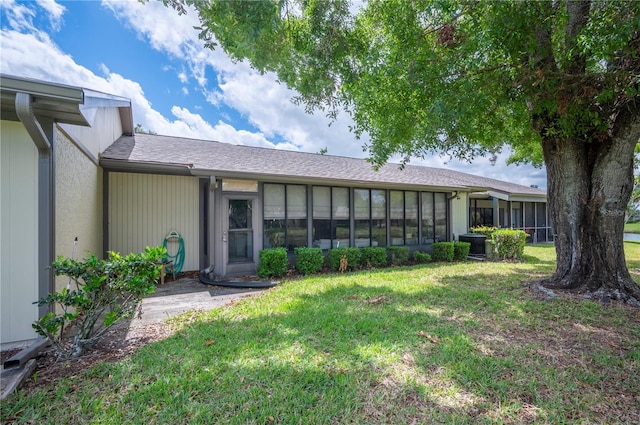 back of house featuring a sunroom and a yard