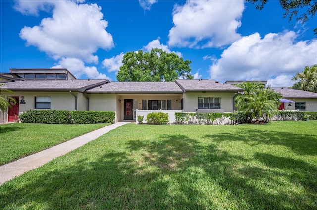 ranch-style home with a front lawn and stucco siding