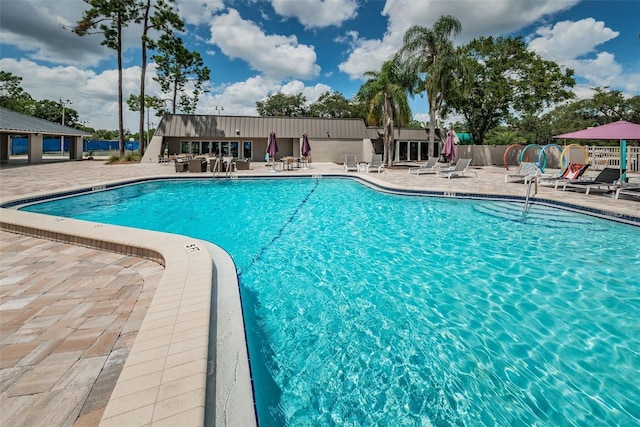 community pool featuring fence and a patio area
