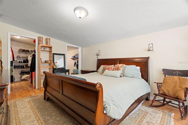 2903 W Paxton Ave, Tampa, FL 33611 - bedroom with a spacious closet, wood finished floors, a closet, a textured ceiling, and lofted ceiling