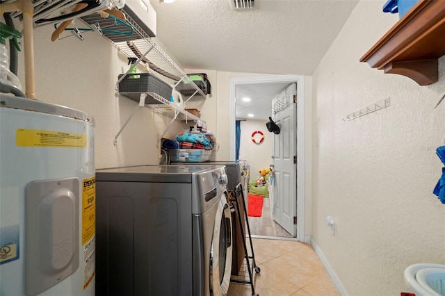 2903 W Paxton Ave, Tampa, FL 33611 - laundry room featuring washing machine and dryer, water heater, light tile patterned floors, and baseboards