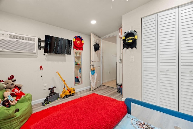 2903 W Paxton Ave, Tampa, FL 33611 - game room featuring light wood-style flooring, a wall mounted air conditioner, lofted ceiling, and baseboards