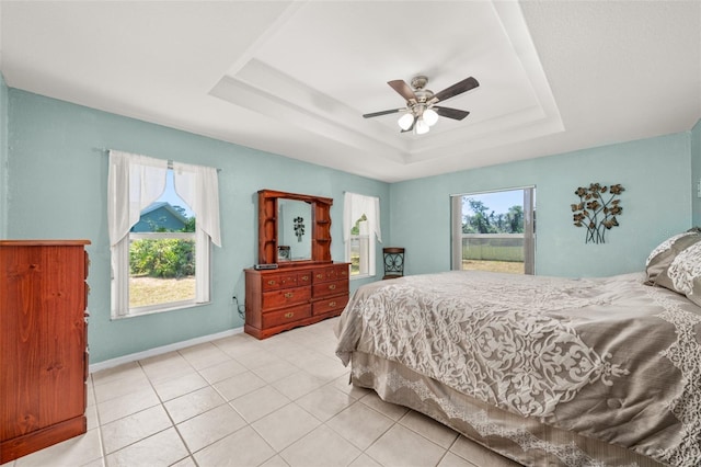 6917 Spumoni St, Sebring, FL 33872 - bedroom with a tray ceiling, light tile patterned floors, a ceiling fan, and baseboards