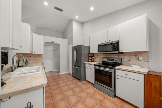 6917 Spumoni St, Sebring, FL 33872 - kitchen featuring stainless steel appliances, a sink, white cabinets, decorative backsplash, and recessed lighting