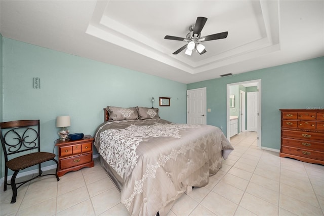 6917 Spumoni St, Sebring, FL 33872 - bedroom featuring a tray ceiling, light tile patterned floors, a ceiling fan, and connected bathroom