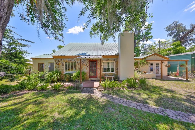 10824 Palmetto St, Riverview, FL 33569 - view of front of property featuring french doors, a chimney, a front yard, and stone siding