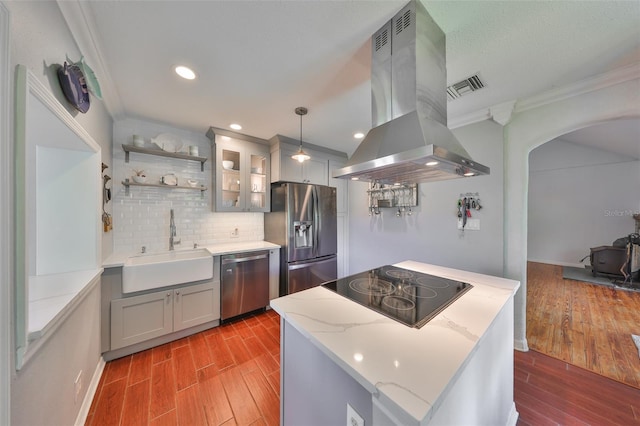10824 Palmetto St, Riverview, FL 33569 - kitchen with stainless steel appliances, island range hood, ornamental molding, a sink, and light wood-type flooring