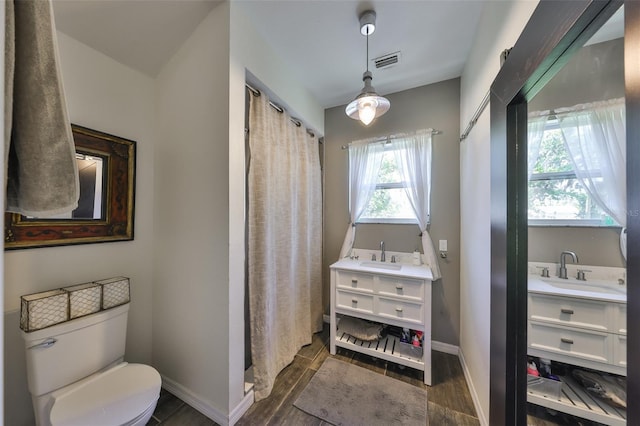 10824 Palmetto St, Riverview, FL 33569 - bathroom with vanity, toilet, wood finished floors, baseboards, and a shower with shower curtain