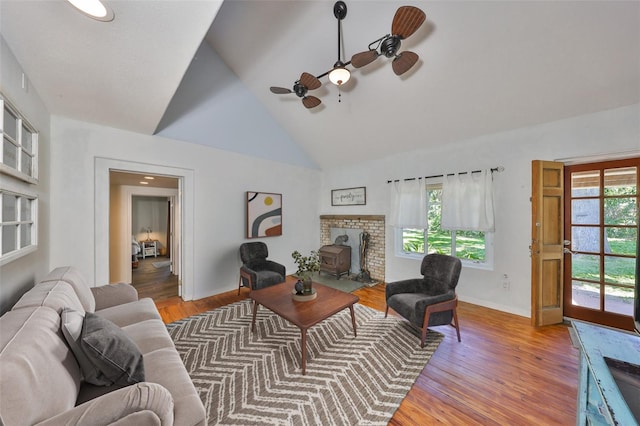 10824 Palmetto St, Riverview, FL 33569 - living area featuring a ceiling fan, a wood stove, light wood-type flooring, baseboards, and high vaulted ceiling