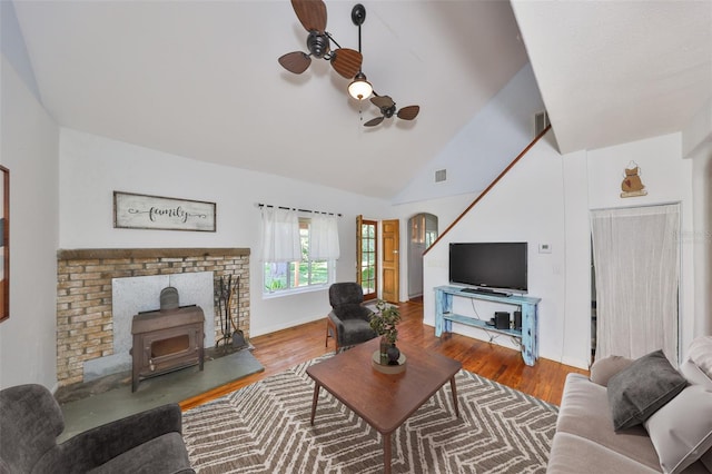 10824 Palmetto St, Riverview, FL 33569 - living area with a wood stove, wood finished floors, a ceiling fan, arched walkways, and high vaulted ceiling