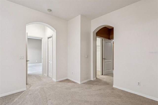 20606 Whitewood Way, Tampa, FL 33647 - spare room with arched walkways, light colored carpet, and baseboards
