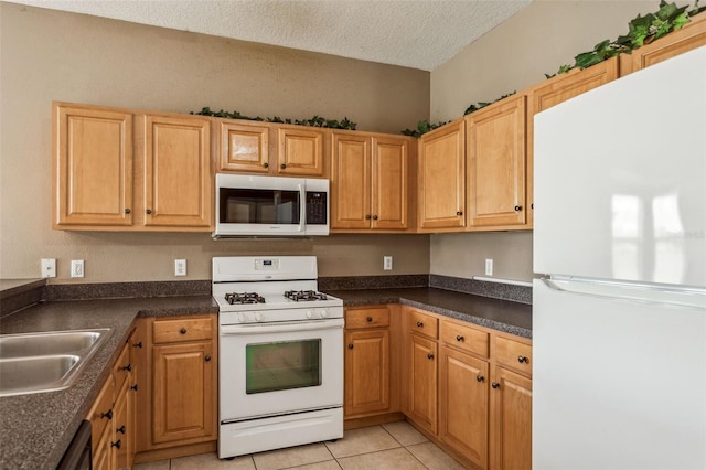 20606 Whitewood Way, Tampa, FL 33647 - kitchen featuring white appliances, a textured ceiling, dark countertops, a sink, and light tile patterned floors