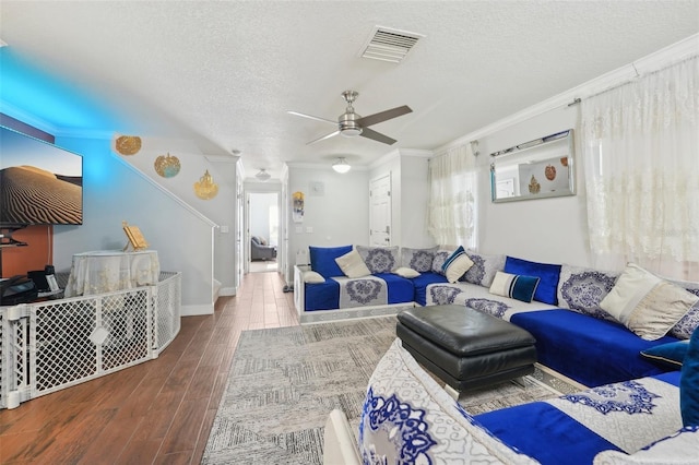living room featuring visible vents, a textured ceiling, ceiling fan, and wood finished floors