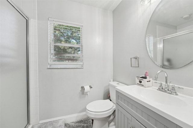 full bath with vanity, a shower with door, baseboards, and toilet