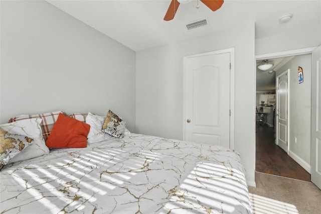 carpeted bedroom with a ceiling fan and visible vents