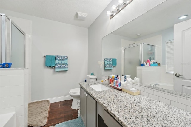 bathroom featuring vanity, baseboards, wood finished floors, a garden tub, and a stall shower