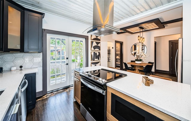 2536 Burlington Ave N, Saint Petersburg, FL 33713 - kitchen with french doors, island exhaust hood, decorative light fixtures, glass insert cabinets, and stainless steel appliances