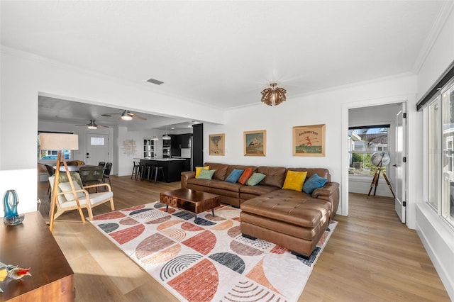 17730 Long Point Dr, Redington Shores, FL 33708 - living room featuring light wood finished floors, a wealth of natural light, ceiling fan, and crown molding