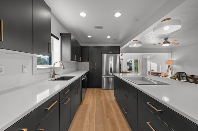 17730 Long Point Dr, Redington Shores, FL 33708 - kitchen with dark cabinetry, stainless steel appliances, light countertops, and a sink