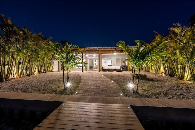 17730 Long Point Dr, Redington Shores, FL 33708 - back of house at night with a pergola, outdoor lounge area, and a patio area